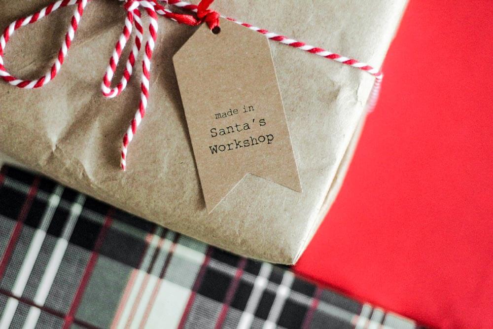 A brown paper wrapped christmas gift with a tag that reads "made in Santa's workshop"
