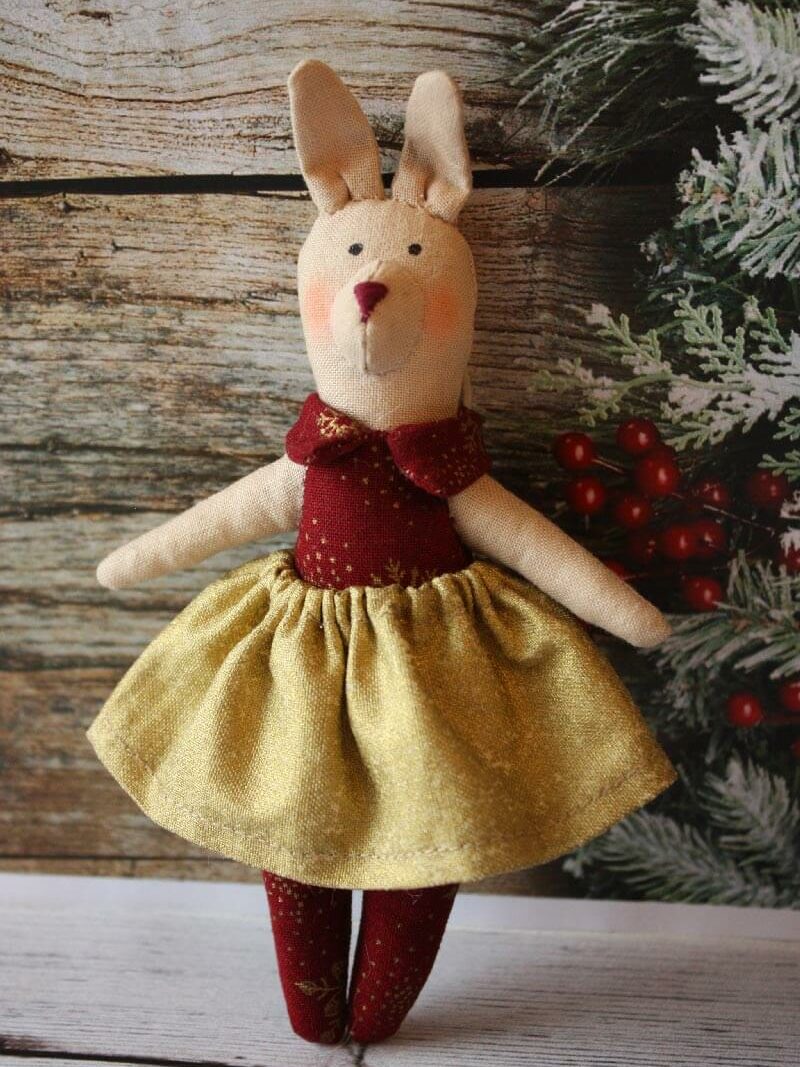 A handmade rabbit doll beside christmas decorations
